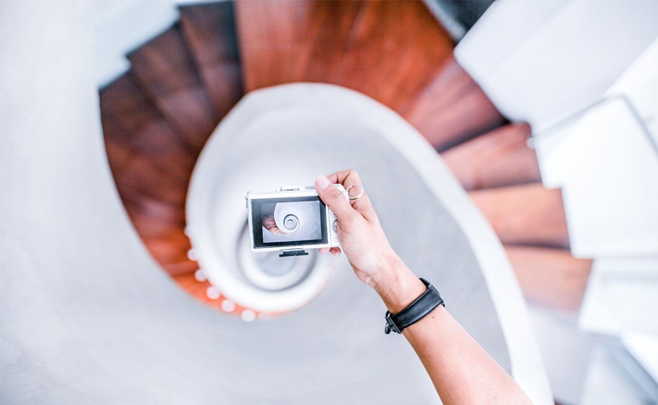 Hand holding a camera, taking a photo of a stairwell